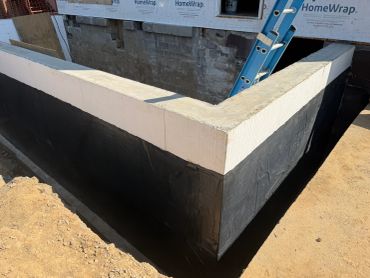 Concrete foundation wall with waterproof coating.