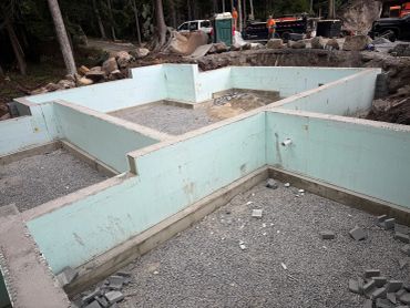 Foundation walls and gravel base of a building under construction.