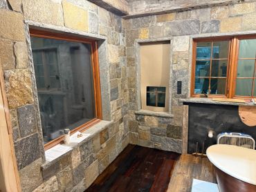 Room with stone walls and a large window.