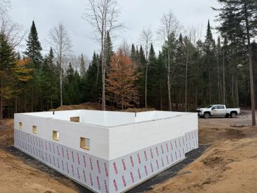 Construction of a house foundation in a forested area.