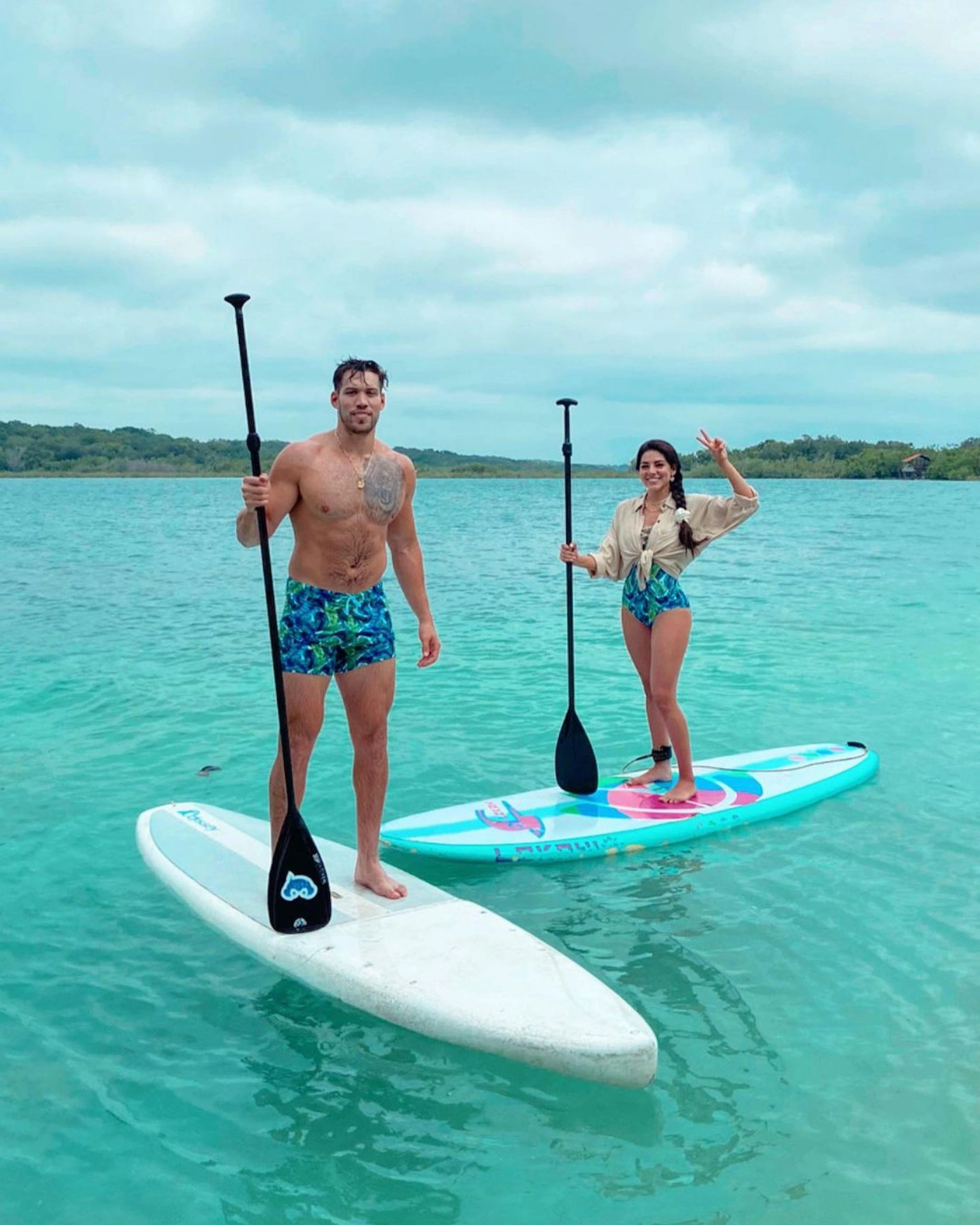 Aguas turquesa y tabla de paddle sobre laguna