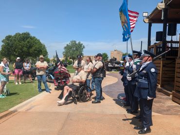 A group honoring veterans with a flag ceremony outdoors.