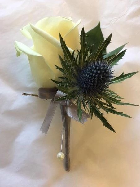 White rose boutonniere with thistle and grey ribbon.