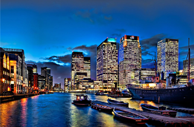 City skyline with boats docked at night.