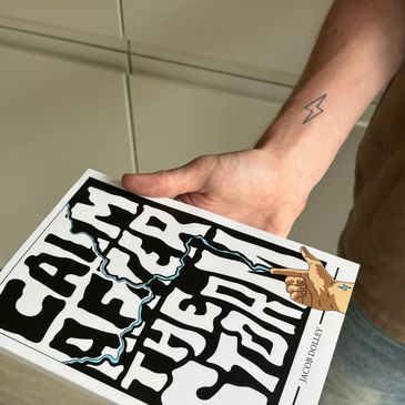 Hand holding a book titled 'Call of the Steel' with a lightning bolt tattoo on the wrist.
