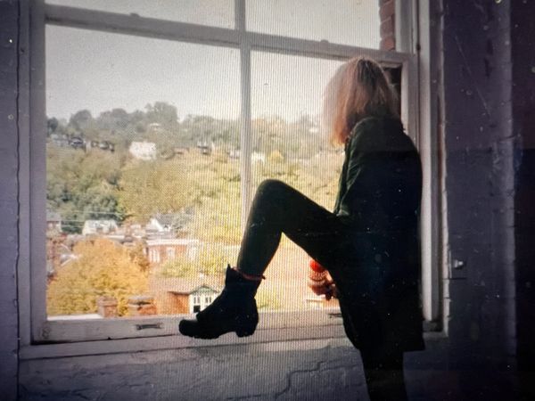 Greer Lankton in 1996 looking out the window at the Mattress Factory Museum. 