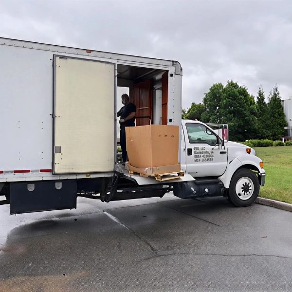 A photo of EcoCycle Services Group truck loading a box of hard drives into their truck. 