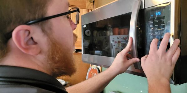 Appliance repair technician working on a Samsung Microwave