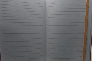 An open notebook with blank lined pages.