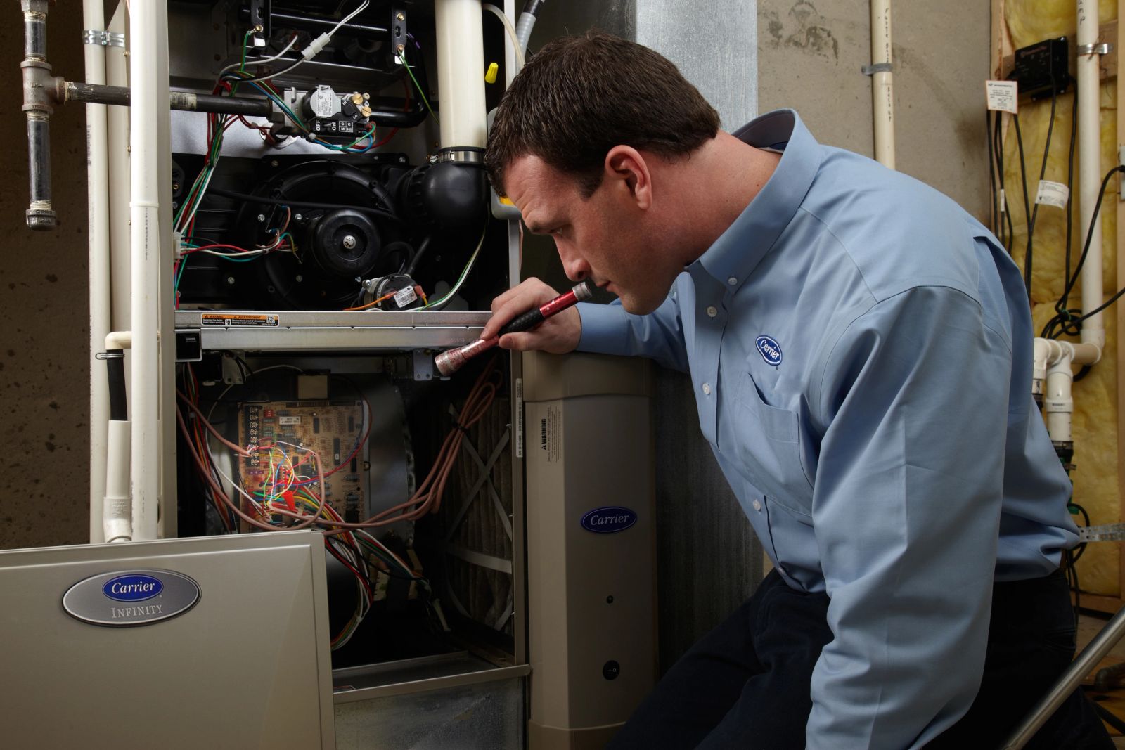 Carrier technician inspecting a residential furnace