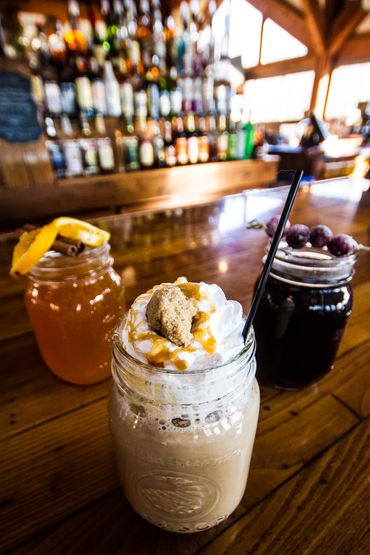Three mixed drinks on a bar.