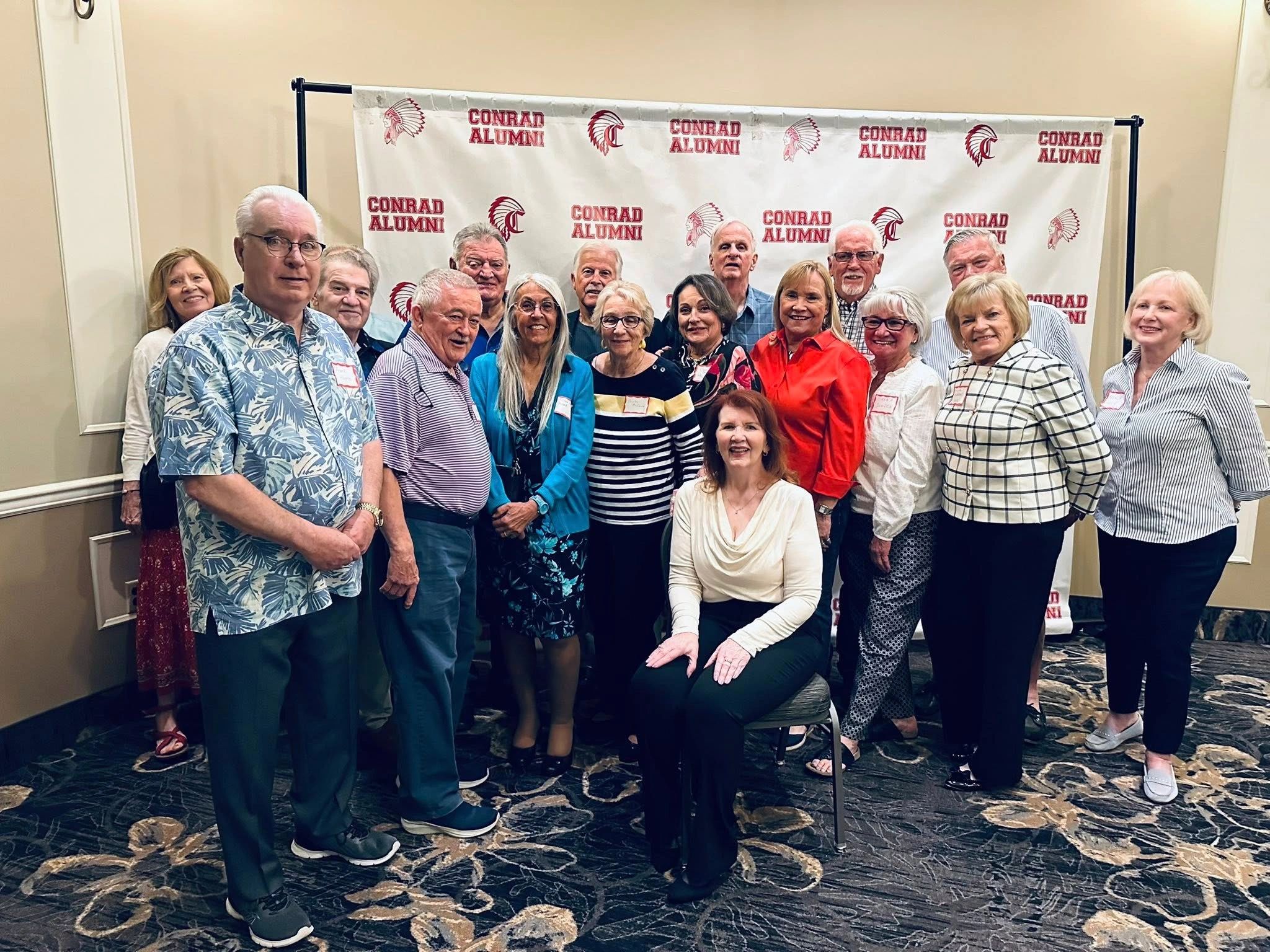 Group of older adults posing at a Conrad Alumni event.