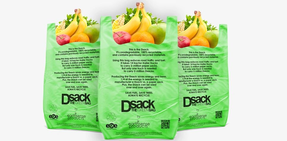 Three green reusable grocery bags with fruits inside.