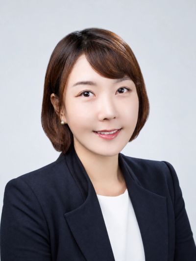Professional woman in a black blazer smiling.