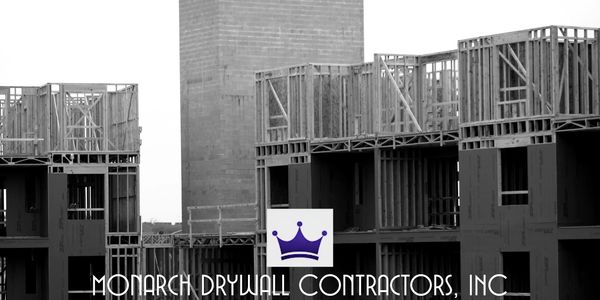 Monarch Drywall Contractors building under construction with logo.