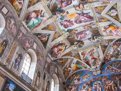 Detailed frescoes cover the ceiling and walls of a historic chapel.