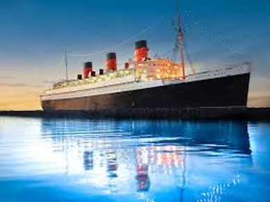 A large ocean liner illuminated at dusk, reflecting on calm water.