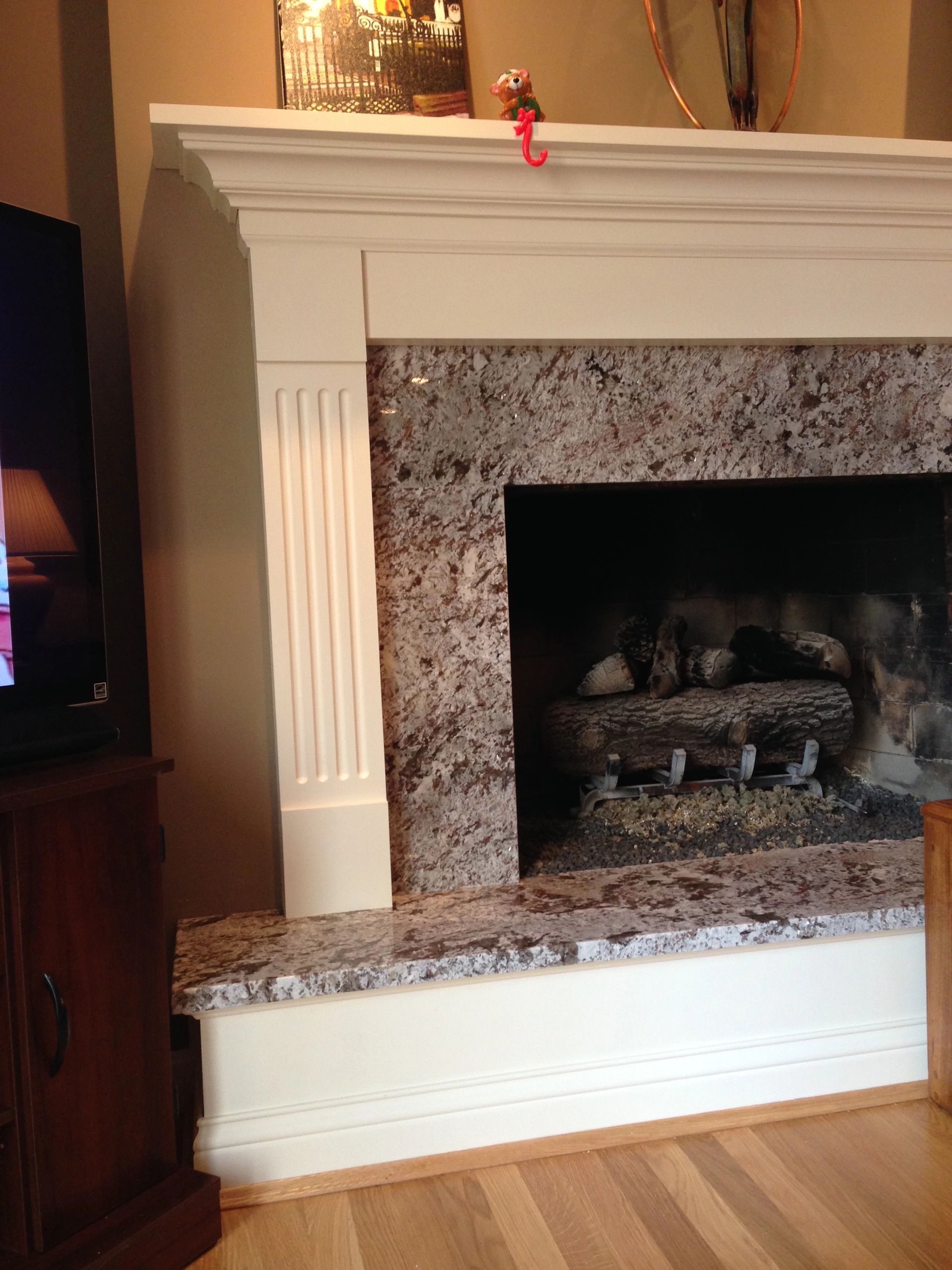 Fireplace with granite surround and wooden mantel.