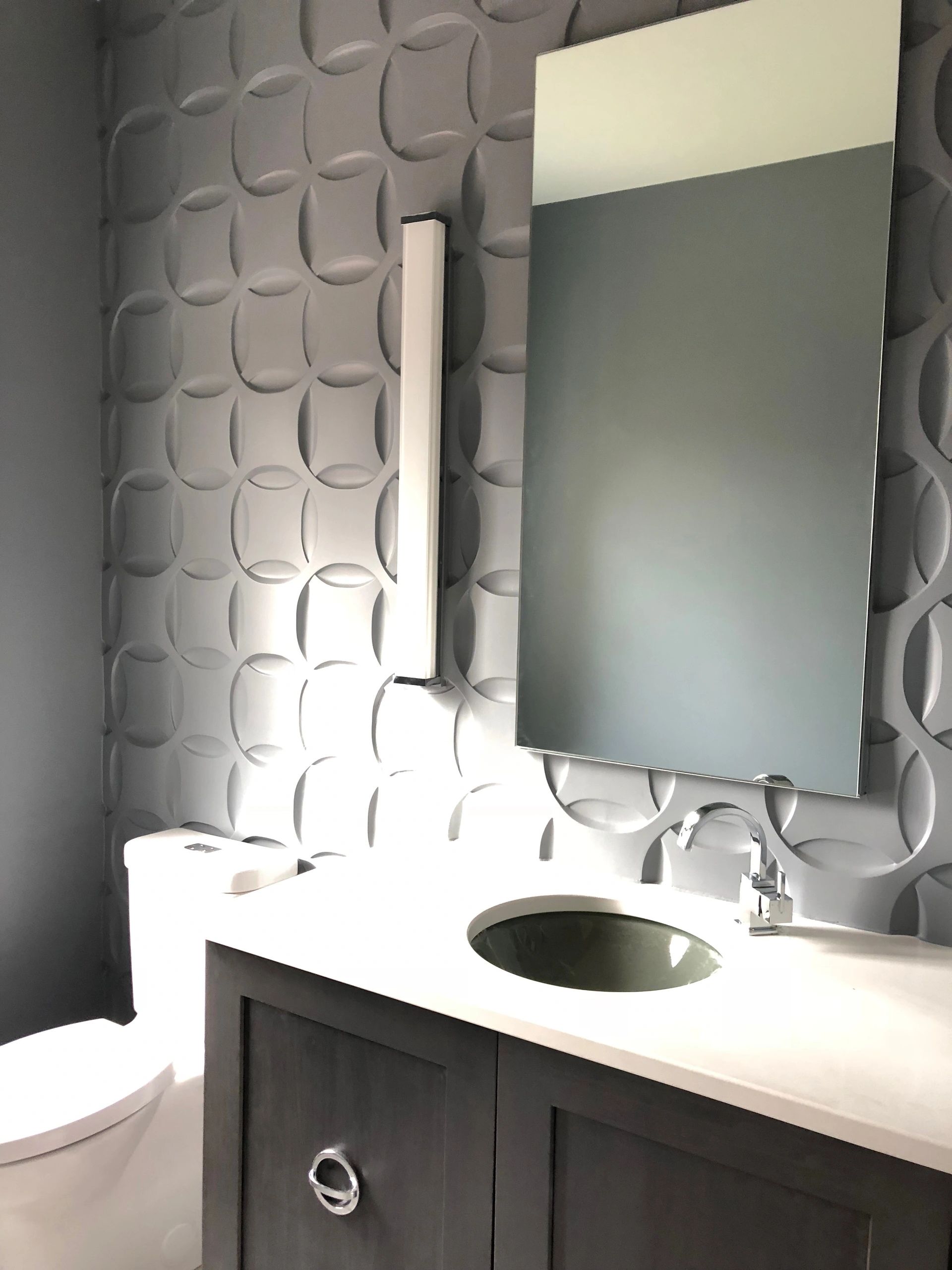 Modern bathroom with geometric wall design and clean sink area.