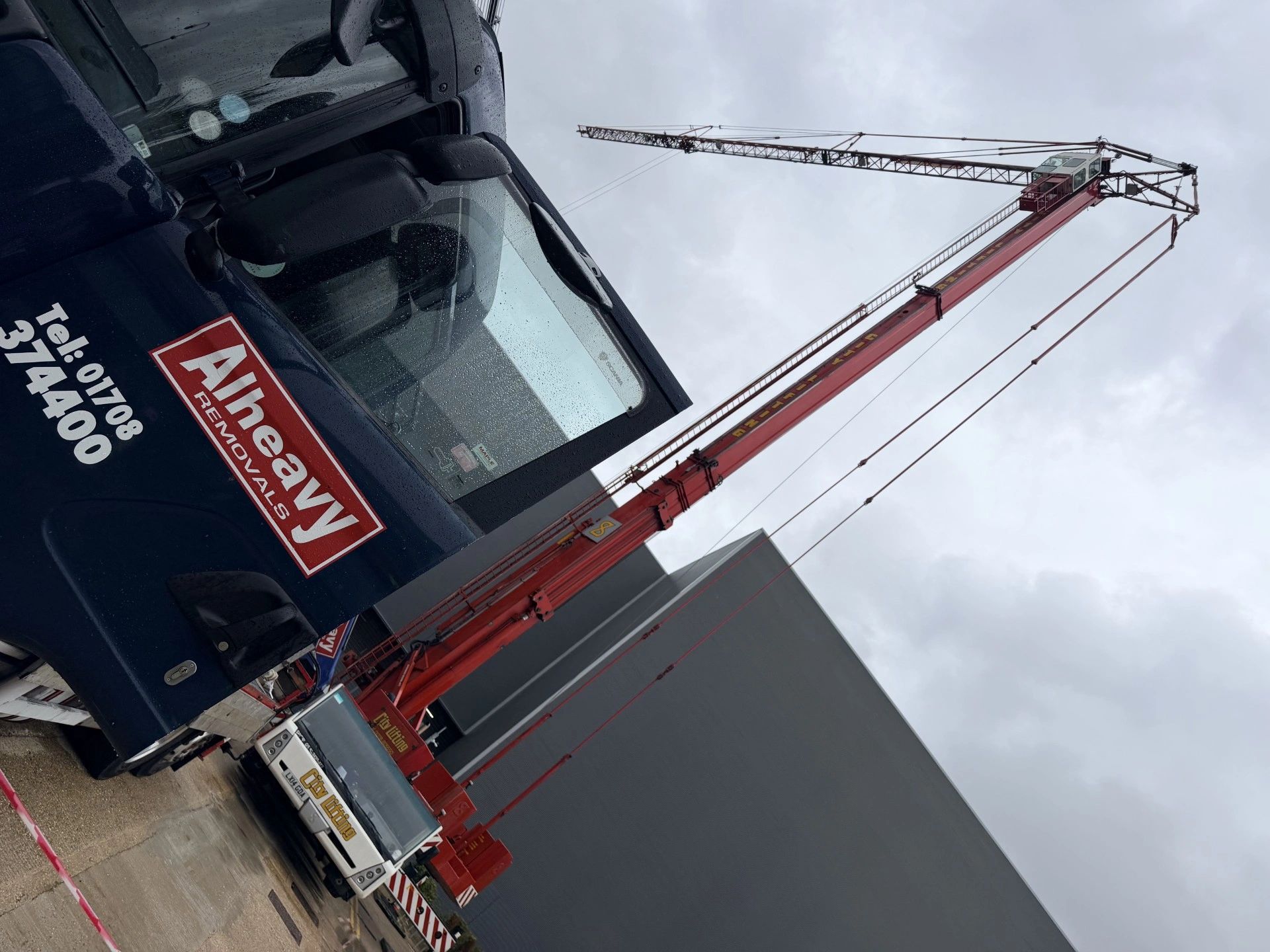 Heavy-duty cranes and trucks at a construction site.