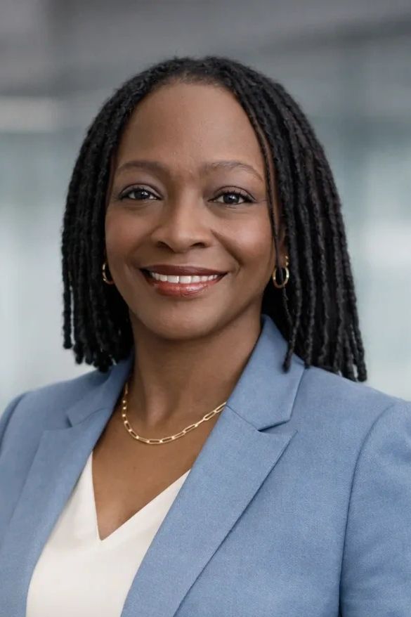 Confident businesswoman in a blue suit smiling warmly.