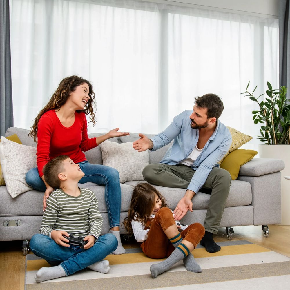 A family enjoying time together playing video games in a cozy living room.