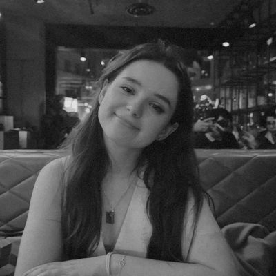 Young woman smiling at a cozy restaurant table.