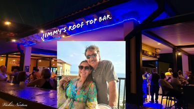 Couple enjoying a sunny day at Jimmy's rooftop bar with a lively evening crowd.