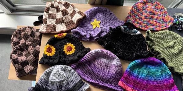 Colorful crocheted hats displayed on a table.
