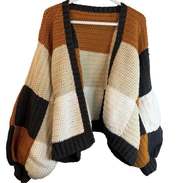 Chunky knit cardigan with color blocks in brown, beige, and black.