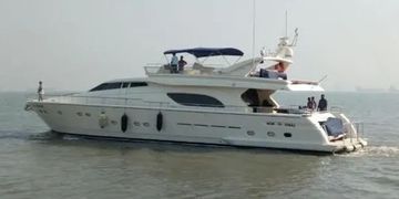 Luxury white yacht cruising on calm water under overcast sky.