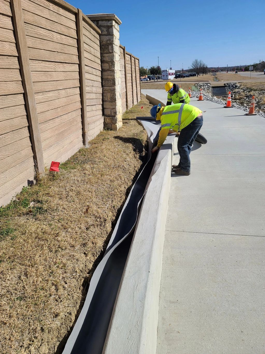 Concrete retaining wall with concrete sidewalk