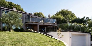 Modern house with a curved balcony and garage.