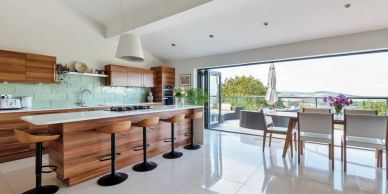 Modern kitchen with wooden cabinets and large window.