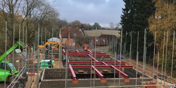 Construction site with brick foundation and steel beams.