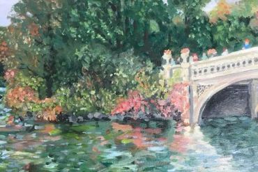A serene riverside scene with a decorative bridge and lush greenery.