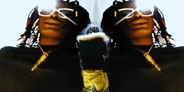 Person with sunglasses and gold chain mirrored effect with raised sneaker.