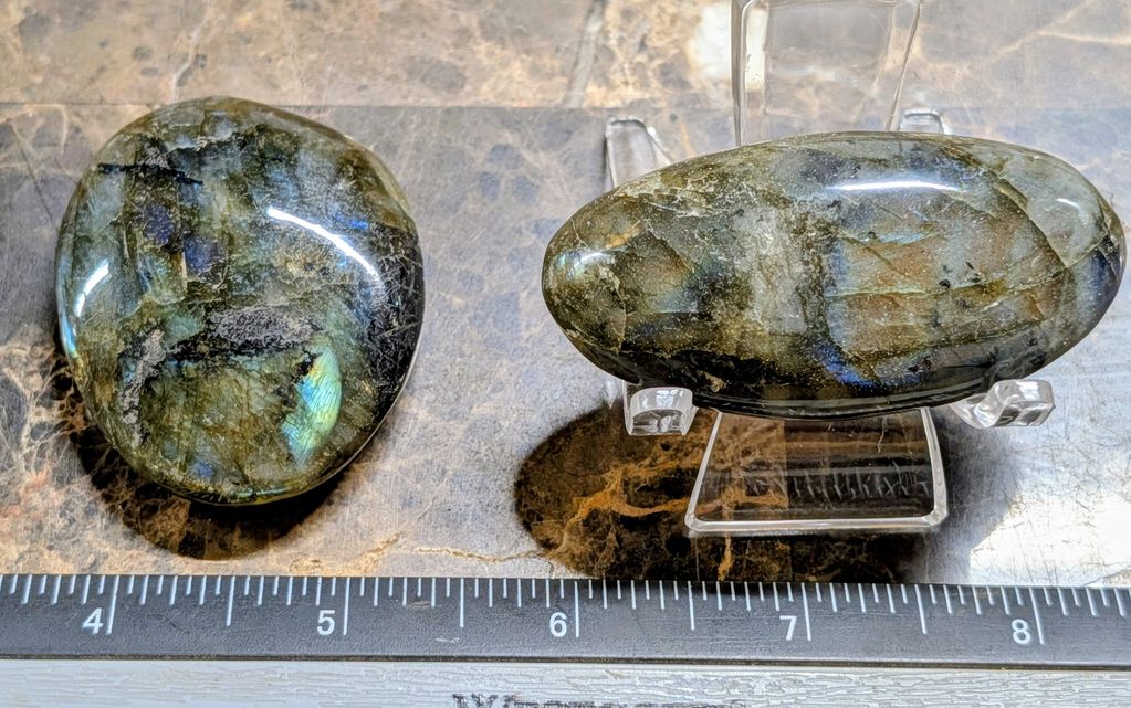 Two polished labradorite stones with a ruler for scale.