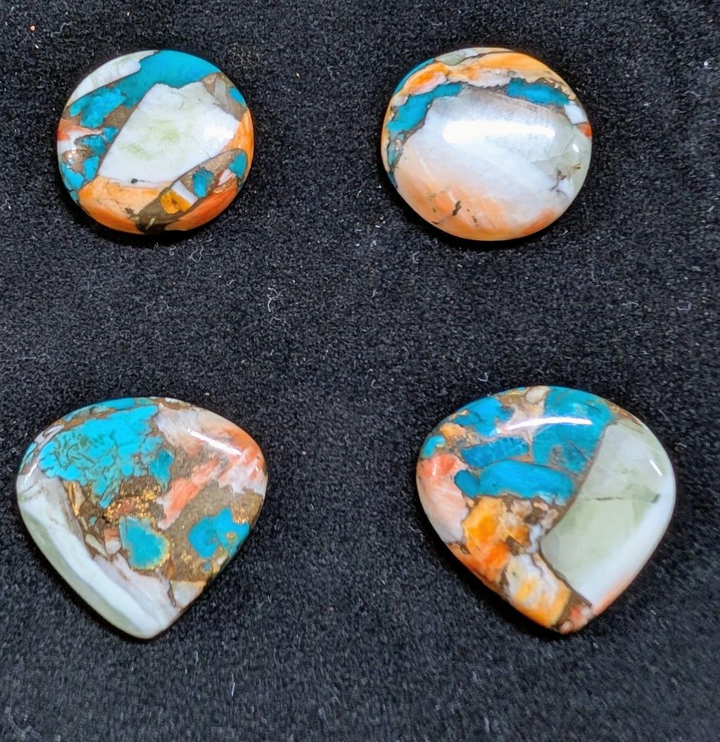 Four colorful polished stones with blue, orange, and white patterns.
