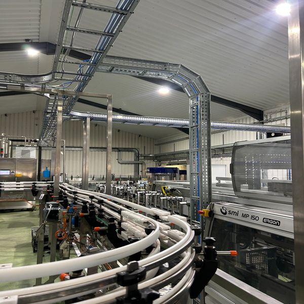 Inside a modern industrial facility with conveyor belts and machinery.
