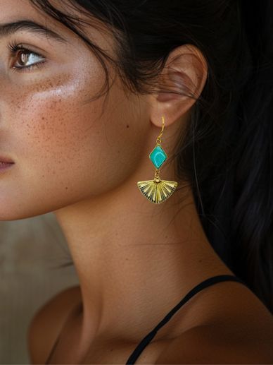 Close-up of a woman wearing a turquoise and gold fan-shaped earring.