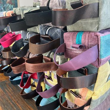 Stacks of assorted colored fabric bags with handles.