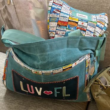 A blue bag with patches and "LUV FL" text.