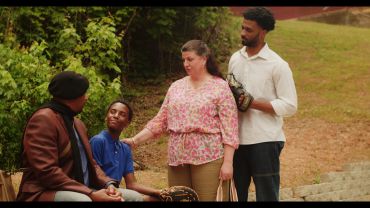 Four people engaged in outdoor conversation.