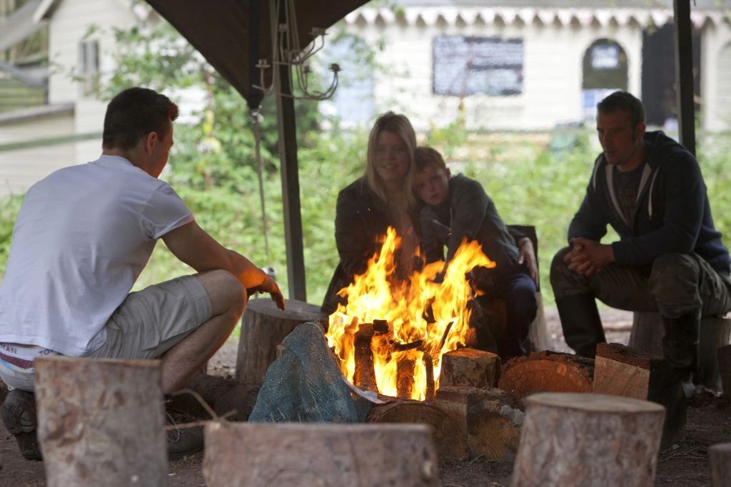 A family gathered round a fire pit outside at The North Star Club.