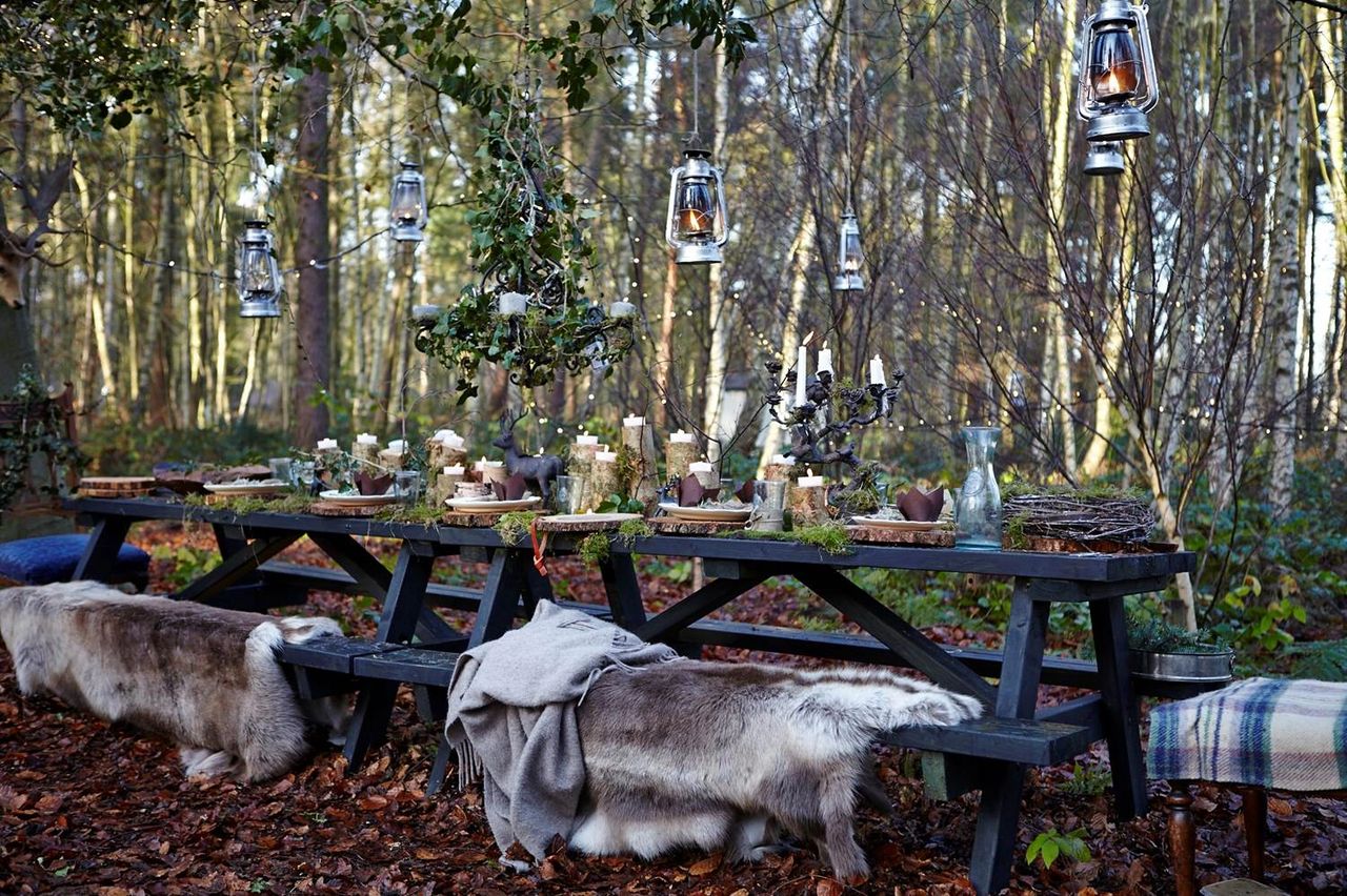 The outdoor picnic table with hanging lanterns hanging above. 