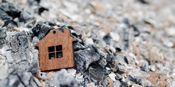 Small wooden home in ashes