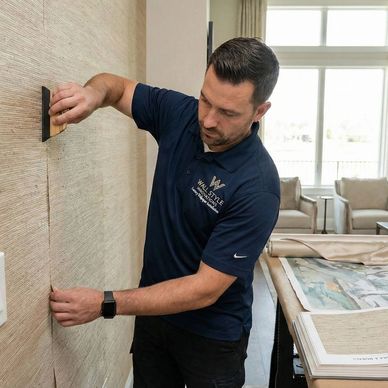 Installer hanging delicate grasscloth wallpaper with invisible seams in a high-end residential home