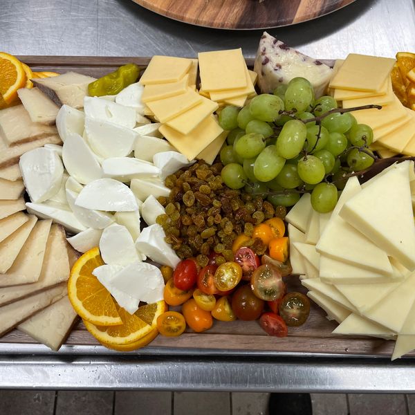Colorful cheese platter with fruits and nuts.