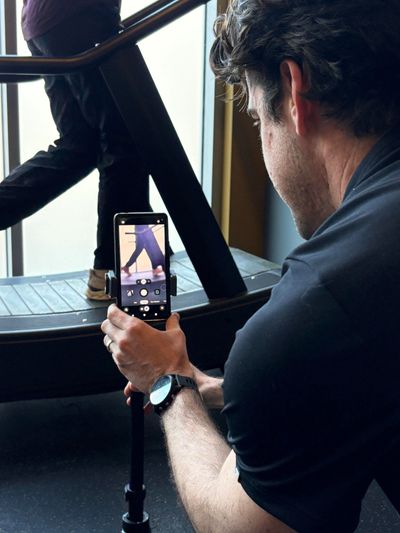 A physical therapist performs a running assessment on a runner patient